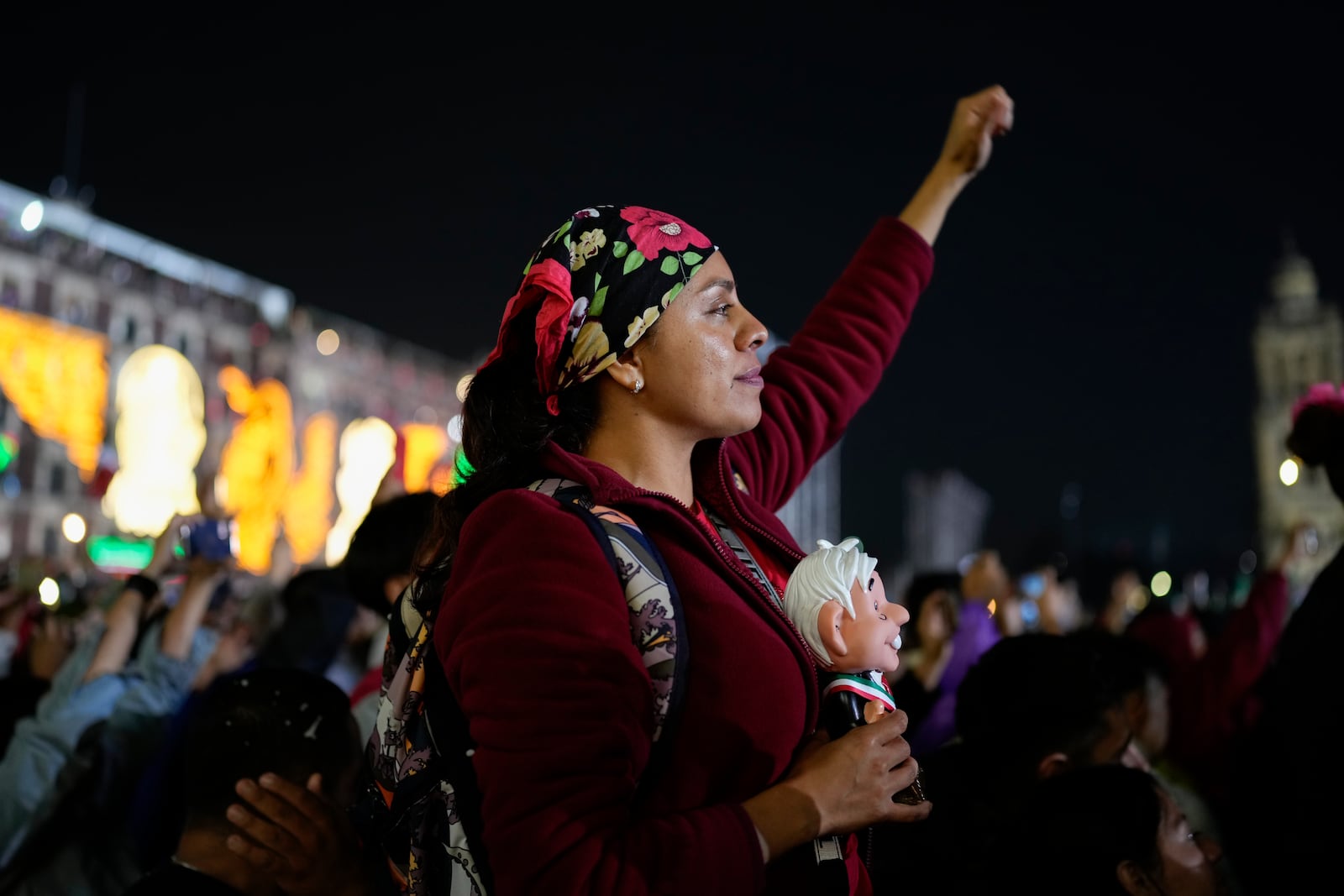 FILE - A supporter of Mexican President Andres Manuel Lopez Obrador holds a doll in his likeness as she listens to him give the annual Independence Day shout from the balcony of the National Palace at the Zocalo in Mexico City, Sept. 15, 2024. (AP Photo/Eduardo Verdugo, File)