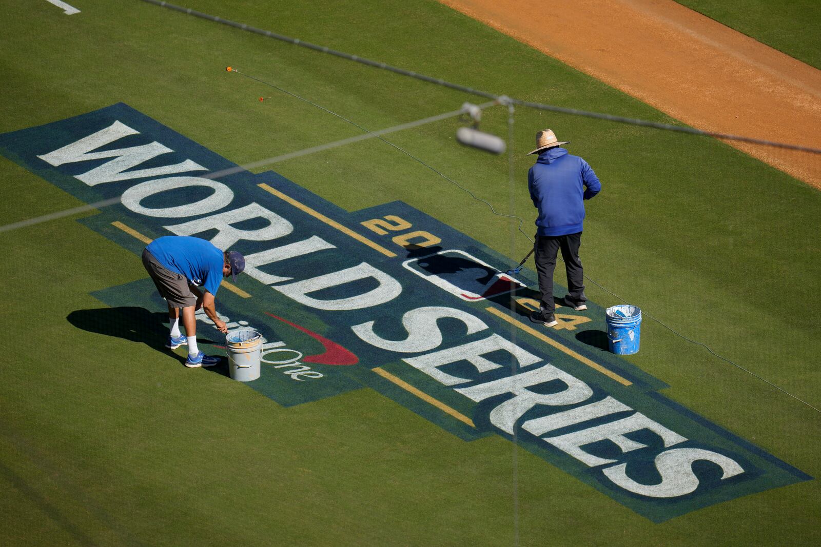 Workers prepare the field for the baseball World Series between the Los Angeles Dodgers and the New York Yankees, Thursday, Oct. 24, 2024, in Los Angeles. (AP Photo/Julio Cortez)