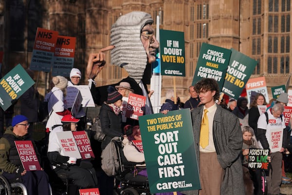 Protesters show posters and placards in front of Parliament in London, Friday, Nov. 29, 2024 as British lawmakers started a historic debate on a proposed to help terminally ill adults end their lives in England and Wales.(AP Photo/Alberto Pezzali)