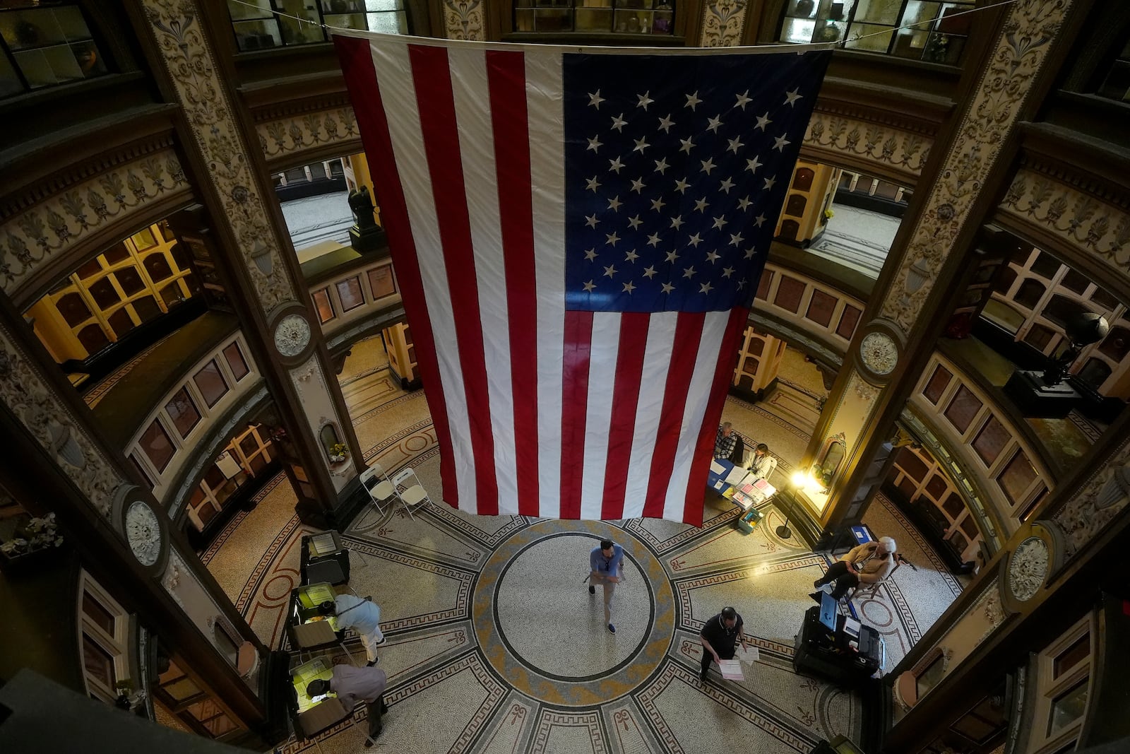 A large flag hangs from the ceiling as people vote at the San Francisco Columbarium & Funeral Home in San Francisco on Election Day, Tuesday, Nov. 5, 2024. (AP Photo/Jeff Chiu)