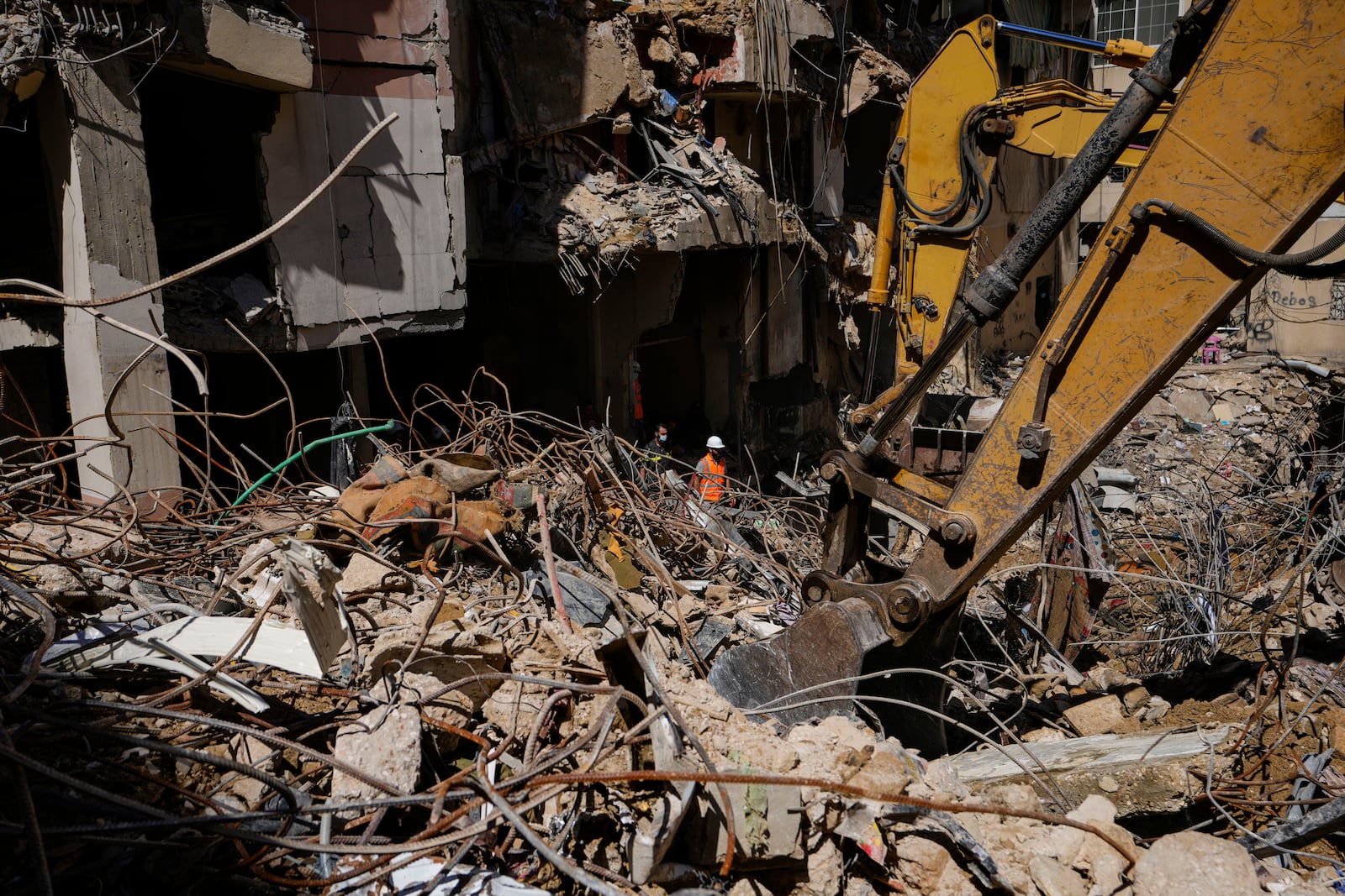 Rescuers sift through the rubble as they search for people still missing at the site of Friday's Israeli strike in Beirut's southern suburbs, Monday, Sept. 23, 2024. (AP Photo/Hassan Ammar)