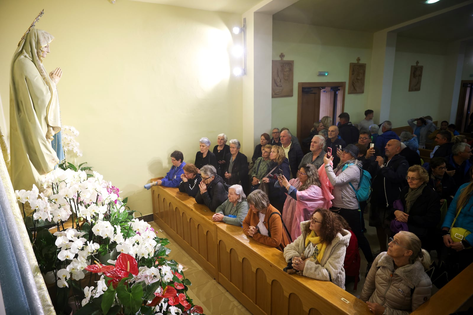 Pilgrims say their prayers next to the statue of the Virgin Mary inside the St. James Church in Medjugorje, Bosnia, Thursday, Sept. 19, 2024. (AP Photo/Armin Durgut)