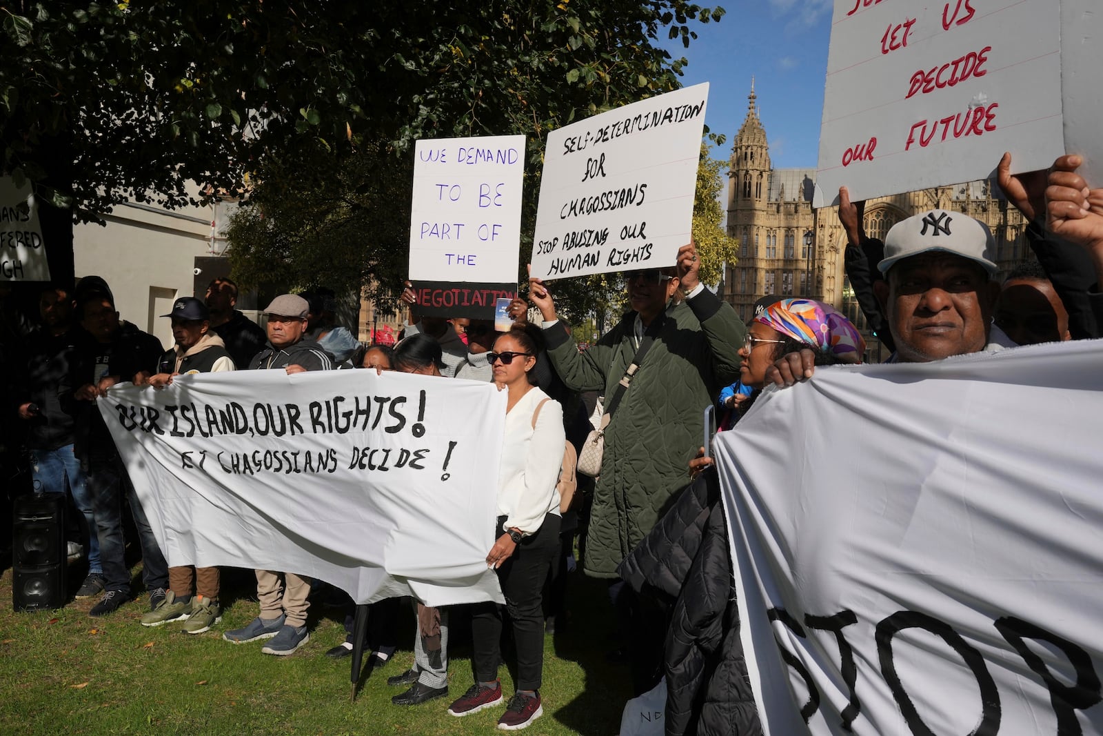 Chagossians attend a protest to respond to the U.K. announcement agreeing to hand sovereignty of the long-contested Chagos Islands to Mauritius and against their "Exclusion" from Chagos negotiations, outside the House of Parliament, in London, Monday, Oct. 7, 2024. (AP Photo/Kin Cheung)