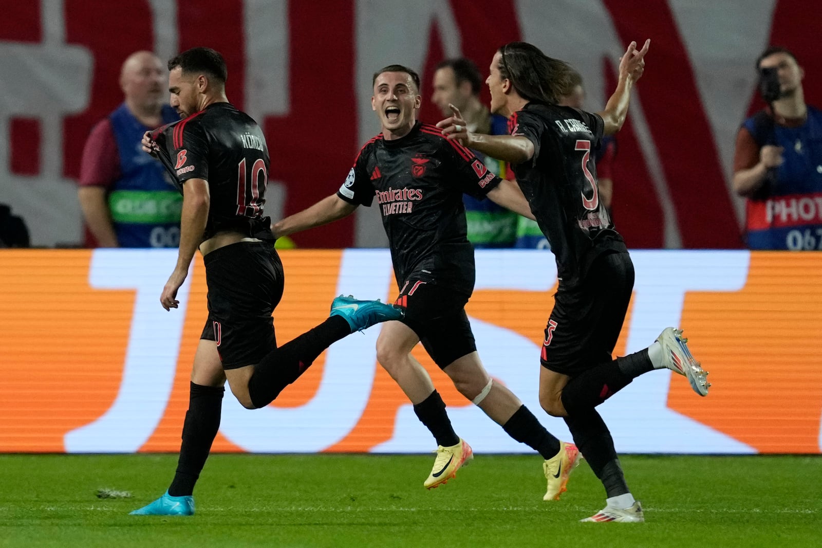 Benfica's Orkun Kokcu, left, celebrates with teammates after scoring his side's second goal during the Champions League opening phase soccer match between Red Star and SL Benfica, at the Rajko Mitic Stadium in Belgrade, Serbia, Thursday, Sept. 19, 2024. (AP Photo/Darko Vojinovic)