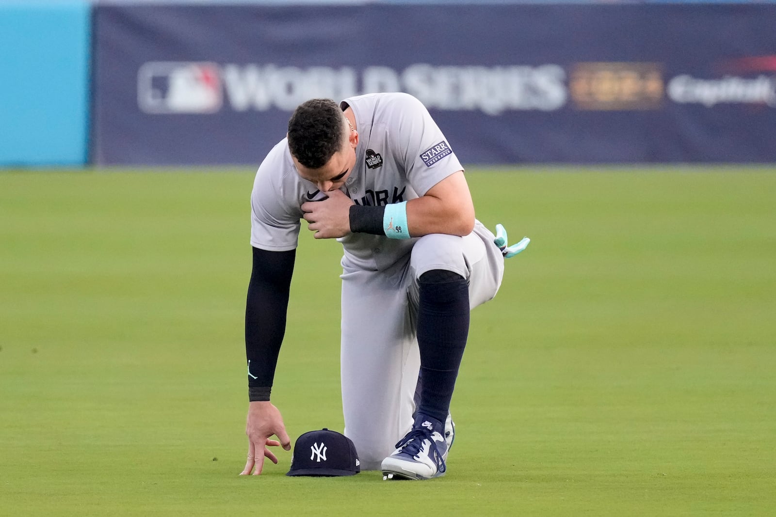 New York Yankees' Aaron Judge kneels in the outfield before Game 2 of the baseball World Series against the Los Angeles Dodgers, Saturday, Oct. 26, 2024, in Los Angeles. (AP Photo/Mark J. Terrill)