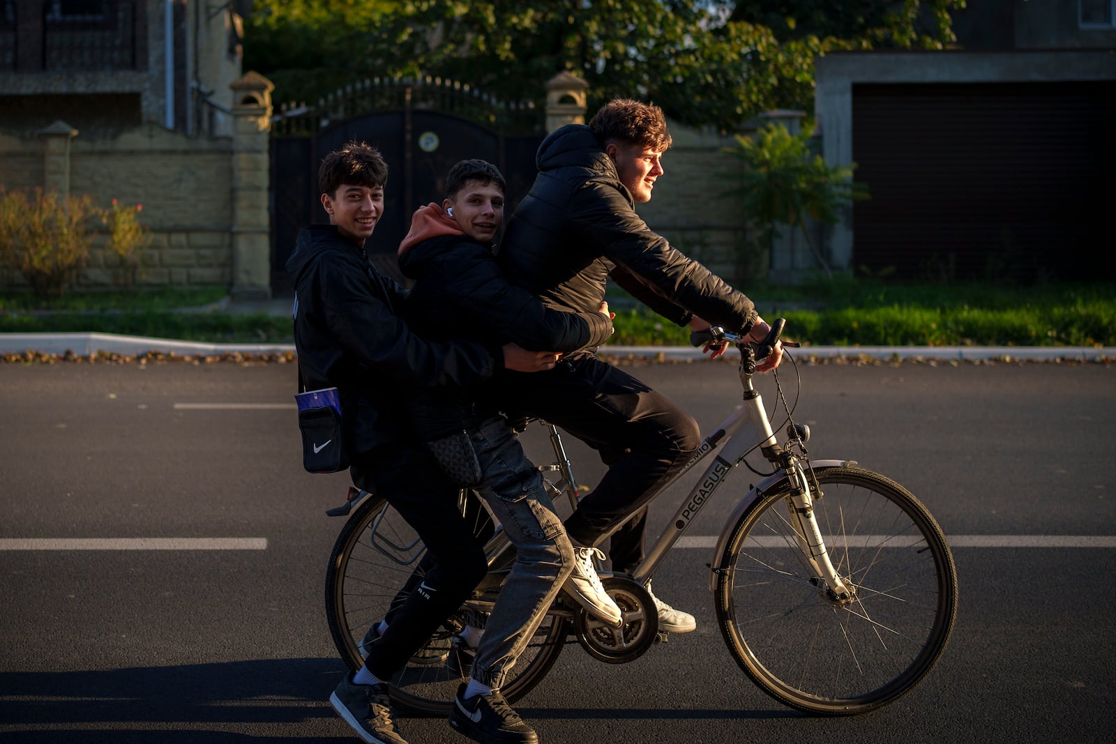 Young people ride a bicycle in Magdacesti, Moldova, Thursday, Oct. 17, 2024, ahead of a presidential election and a referendum of whether to enshrine in Moldova's Constitution its path to European Union membership taking place on Oct.20. (AP Photo/Vadim Ghirda)