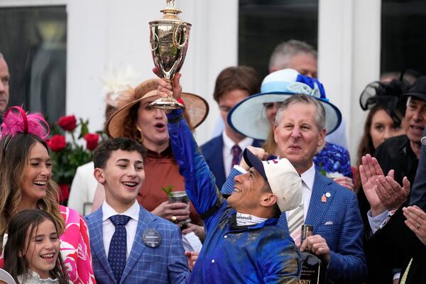 Junior Alvarado holds the trophy as he celebrates after riding Sovereignty to victory in the 151st running of the Kentucky Derby horse race at Churchill Downs Saturday, May 3, 2025, in Louisville, Ky. (AP Photo/Brynn Anderson)