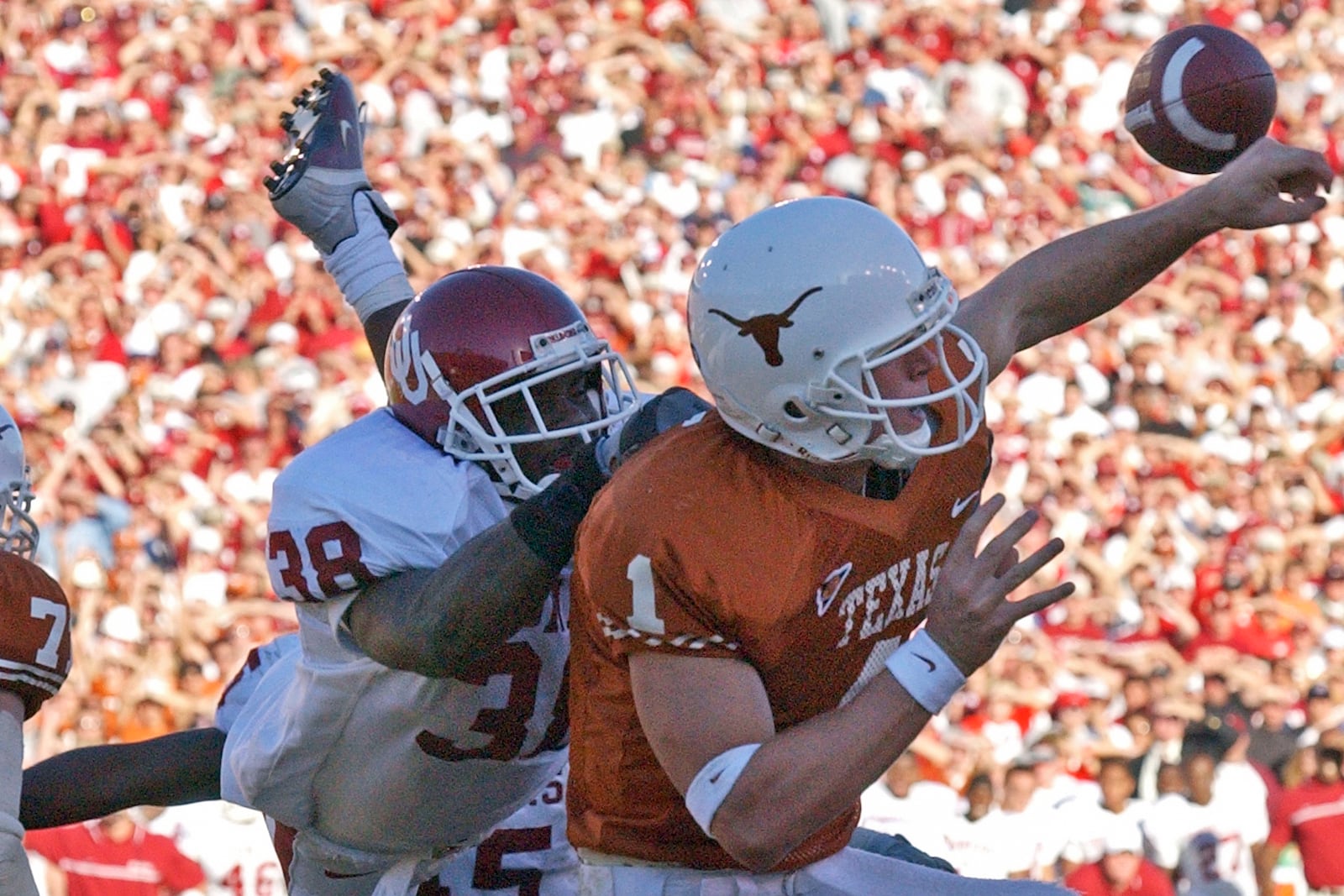 FILE - -Texas quarterback Chris Simms (1) is hit by Oklahoma's Roy Williams (38) in the fourth quarter, causing Simms to throw an interception to Oklahoma's Teddy Lehman, Saturday, Oct. 6, 2001, in Dallas. Lehman returned the interception 2 yards for a touchdown and Oklahoma won 14-3. (AP Photo/Tim Sharp, File)