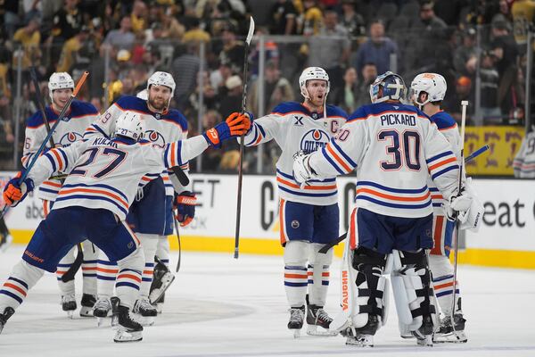 Edmonton Oilers celebrate after defeating the Vegas Golden Knights in overtime of Game 2 of a second-round NHL hockey playoff series Thursday, May 8, 2025, in Las Vegas. (AP Photo/John Locher)