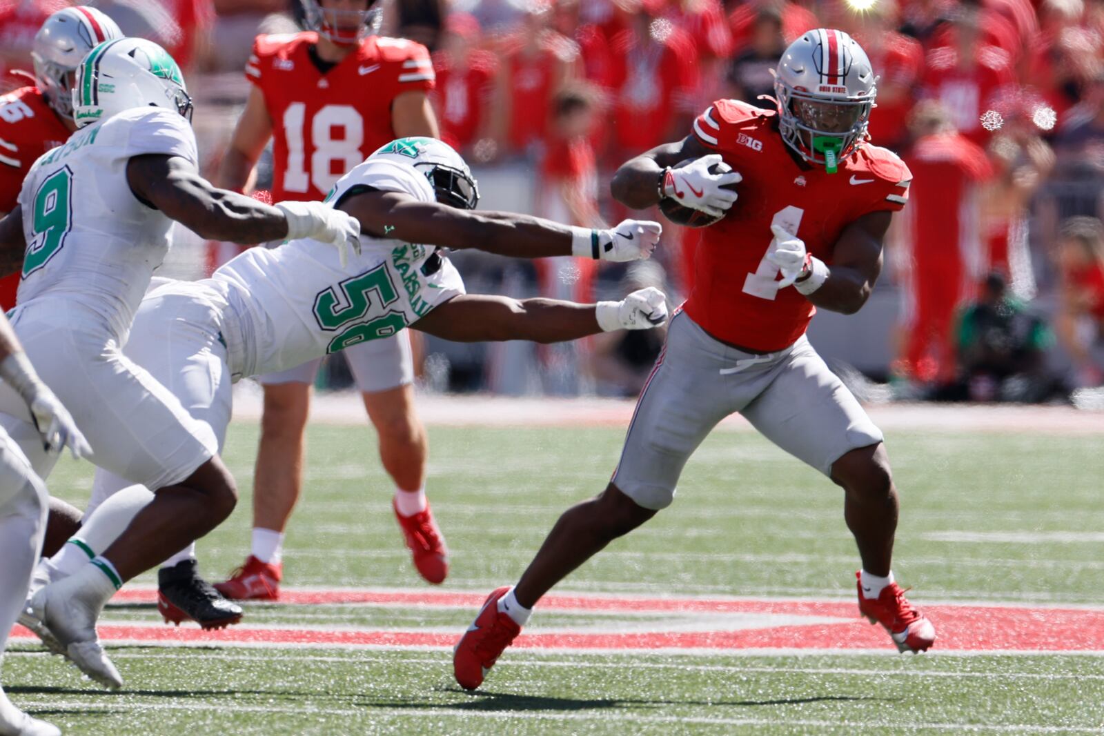 Ohio State running back Quinshon Judkins, right, tries to get away from Marshall defensive lineman Braydin Ward during the second half of an NCAA college football game, Saturday, Sept. 21, 2024, in Columbus, Ohio. (AP Photo/Jay LaPrete)