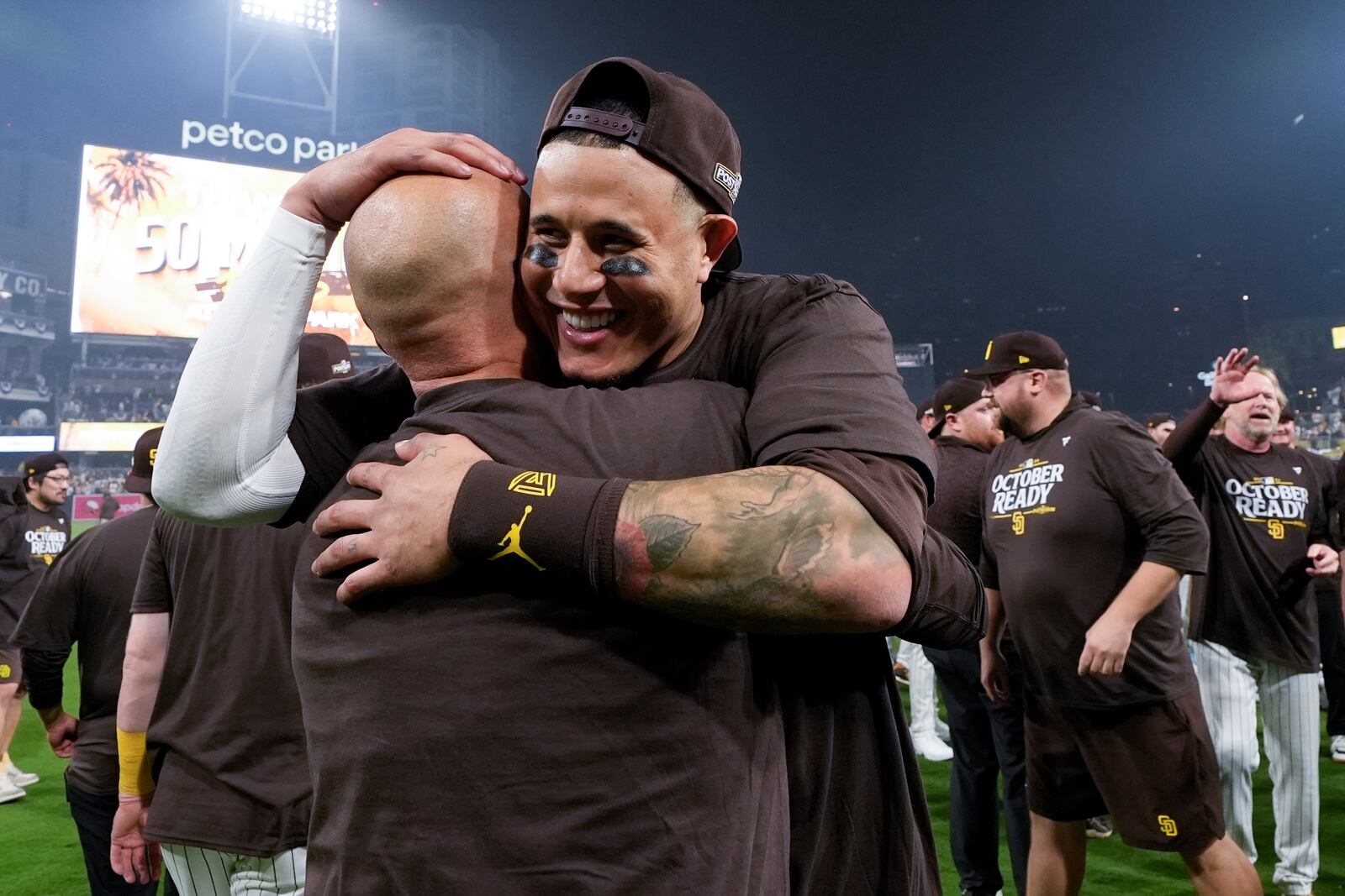 San Diego Padres' Manny Machado hugs bullpen catcher Gilberto Andrade after a win over the Atlanta Braves in Game 2 of an NL Wild Card Series baseball game Wednesday, Oct. 2, 2024, in San Diego. (AP Photo/Gregory Bull)