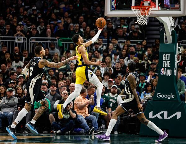 Indiana Pacers' Tyrese Haliburton, middle, puts up a shot against the Milwaukee Bucks during the first half of Game 4 of a first-round NBA basketball playoff series Sunday, April 27, 2025, in Milwaukee. (AP Photo/Jeffrey Phelps)