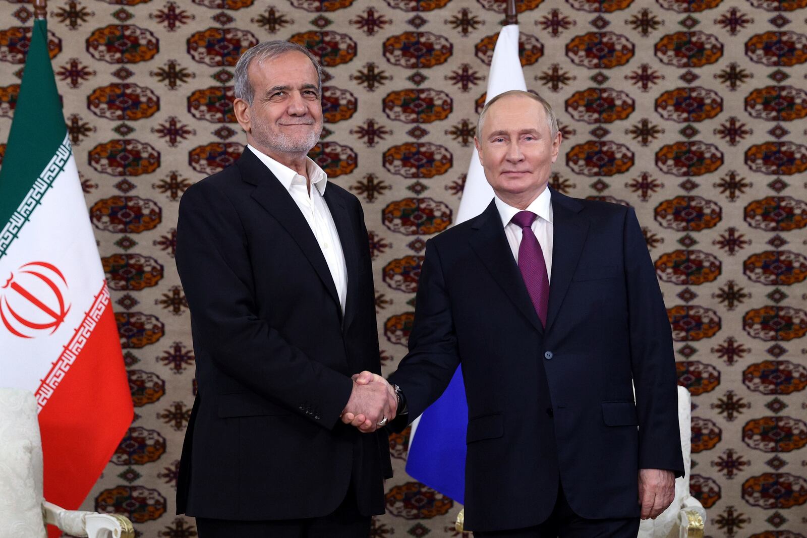 Russian President Vladimir Putin, right, and Iranian President Masoud Pezeshkian shake hands during their meeting on the sidelines of the International Forum "The Interconnection of Times and Civilizations – the basis of peace and development" dedicated to the 300th anniversary of the birth of the outstanding Turkmen poet and thinker Magtymguly Fragi in Ashgabat, Turkmenistan, Friday, Oct. 11, 2024. (Alexander Shcherbak, Sputnik, Kremlin Pool Photo via AP)