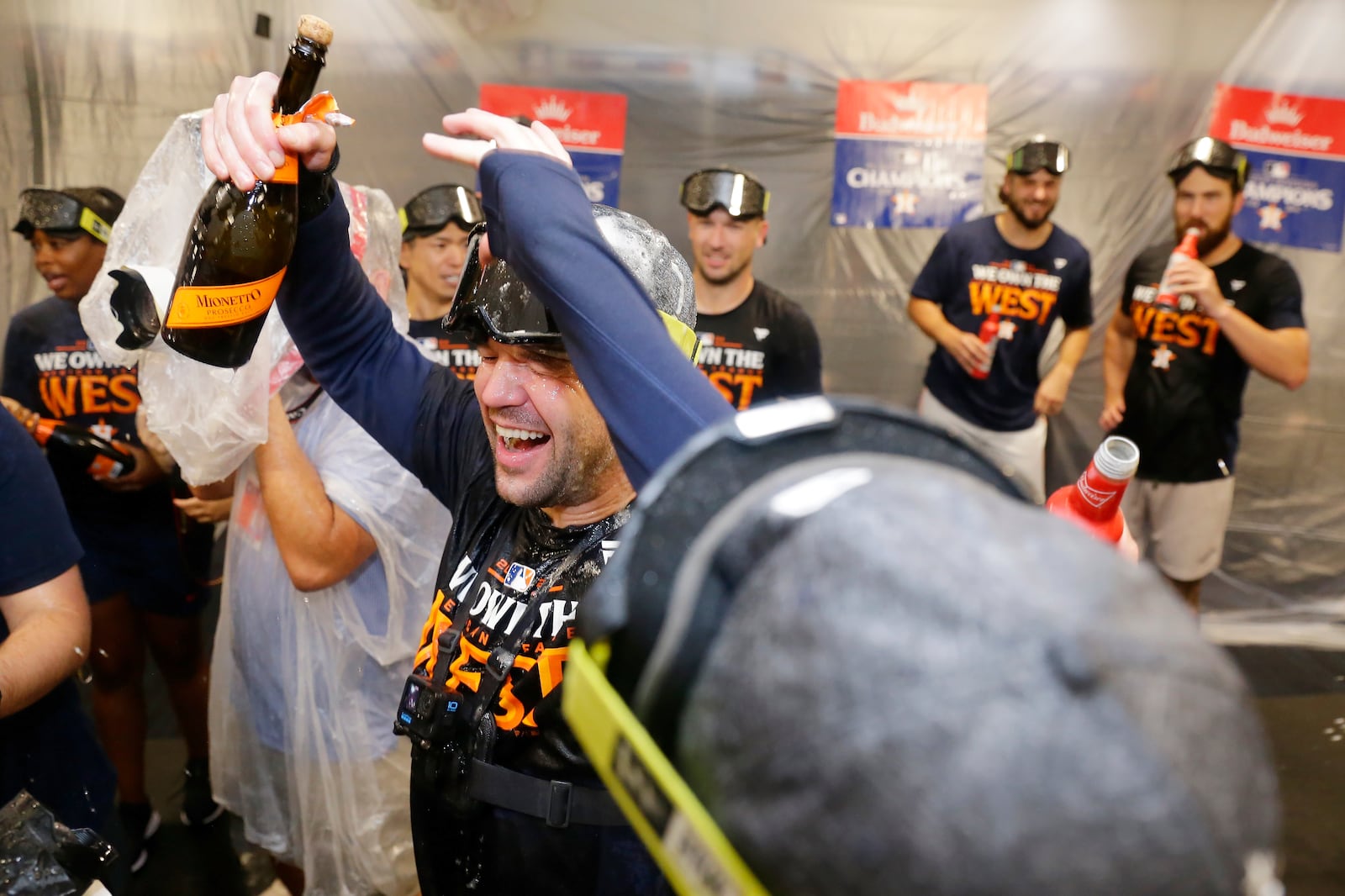 Houston Astros' Chas McCormick, center, is doused with champagne as the team celebrates in the clubhouse after defeating the Seattle Mariners 4-3 to clinch the AL West title after a baseball game Tuesday, Sept. 24, 2024, in Houston. (AP Photo/Michael Wyke)