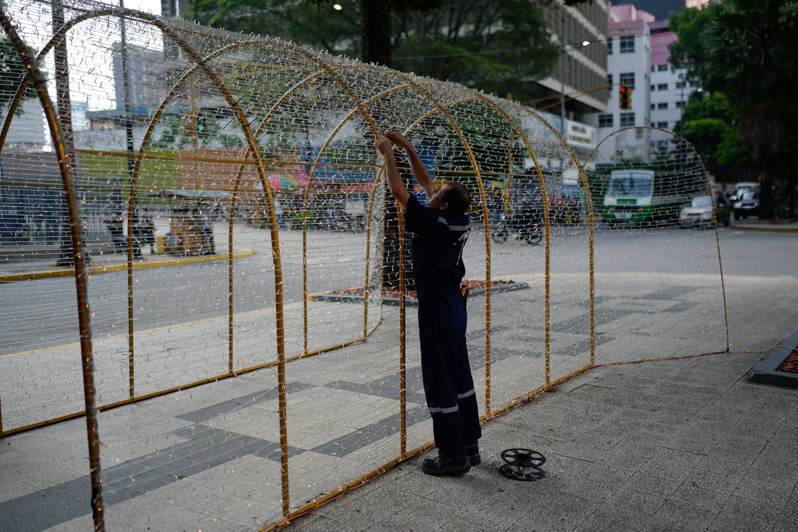 A worker sets up Christmas lights in Caracas, Venezuela, Tuesday, Oct. 1, 2024. (AP Photo/Ariana Cubillos)