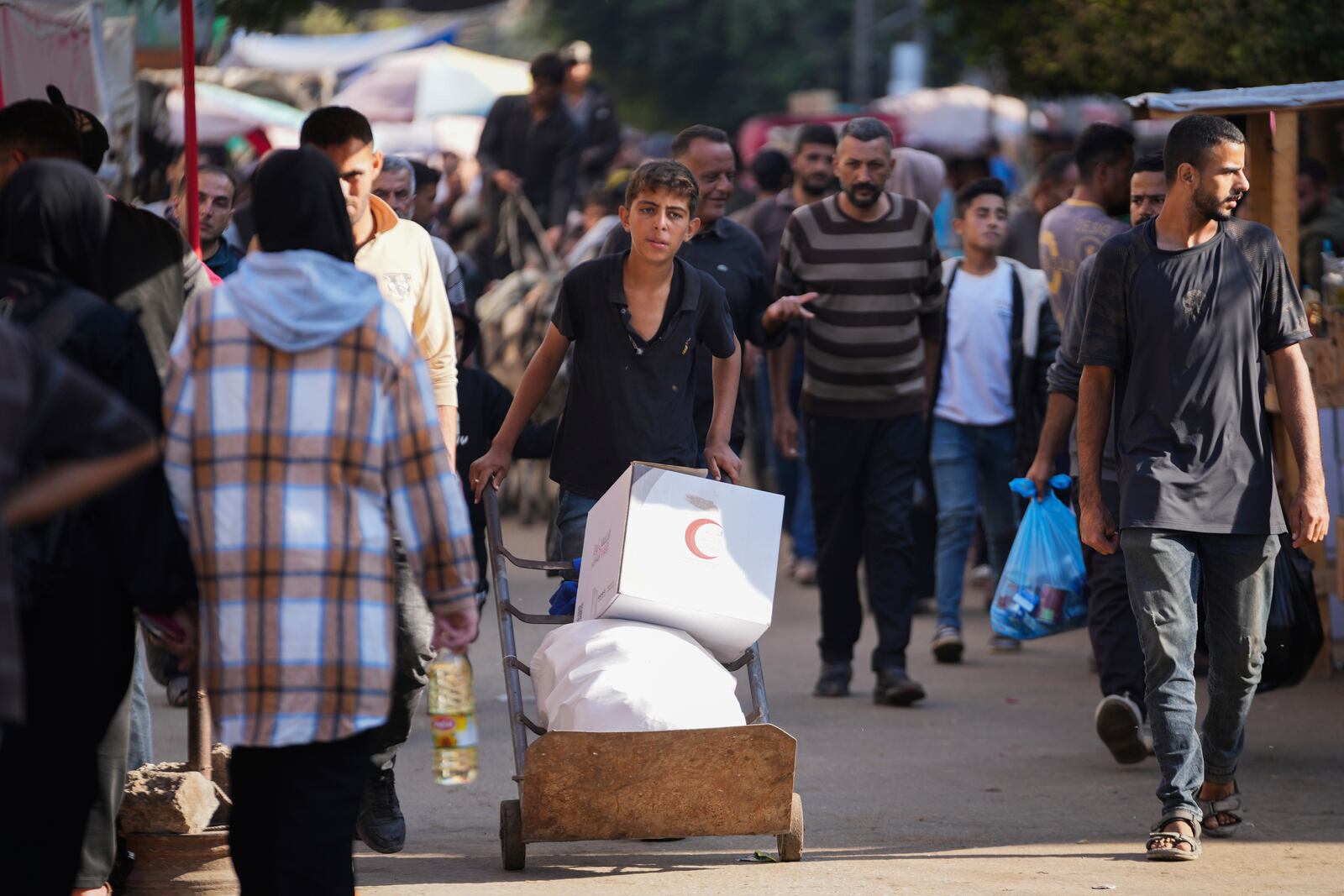 A Palestinian youth carries humanitarian aid in Deir al-Balah, Gaza, Wednesday, Nov. 13, 2024. (AP Photo/Abdel Kareem Hana)