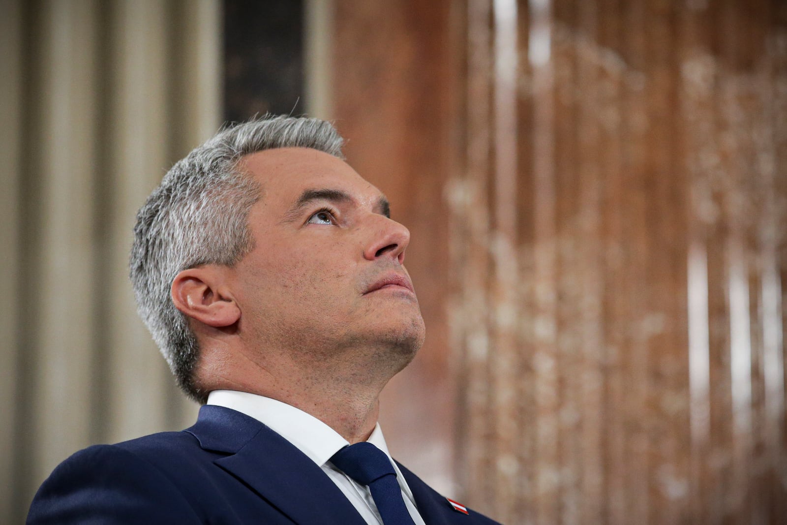 Austrian Chancellor Karl Nehammer looks up while attending a debate at the national broadcaster studio, set up in the parliament building, in Vienna, Austria, Sunday, Sept. 29, 2024, after polls closed in the country's national election. (AP Photo/Heinz-Peter Bader)