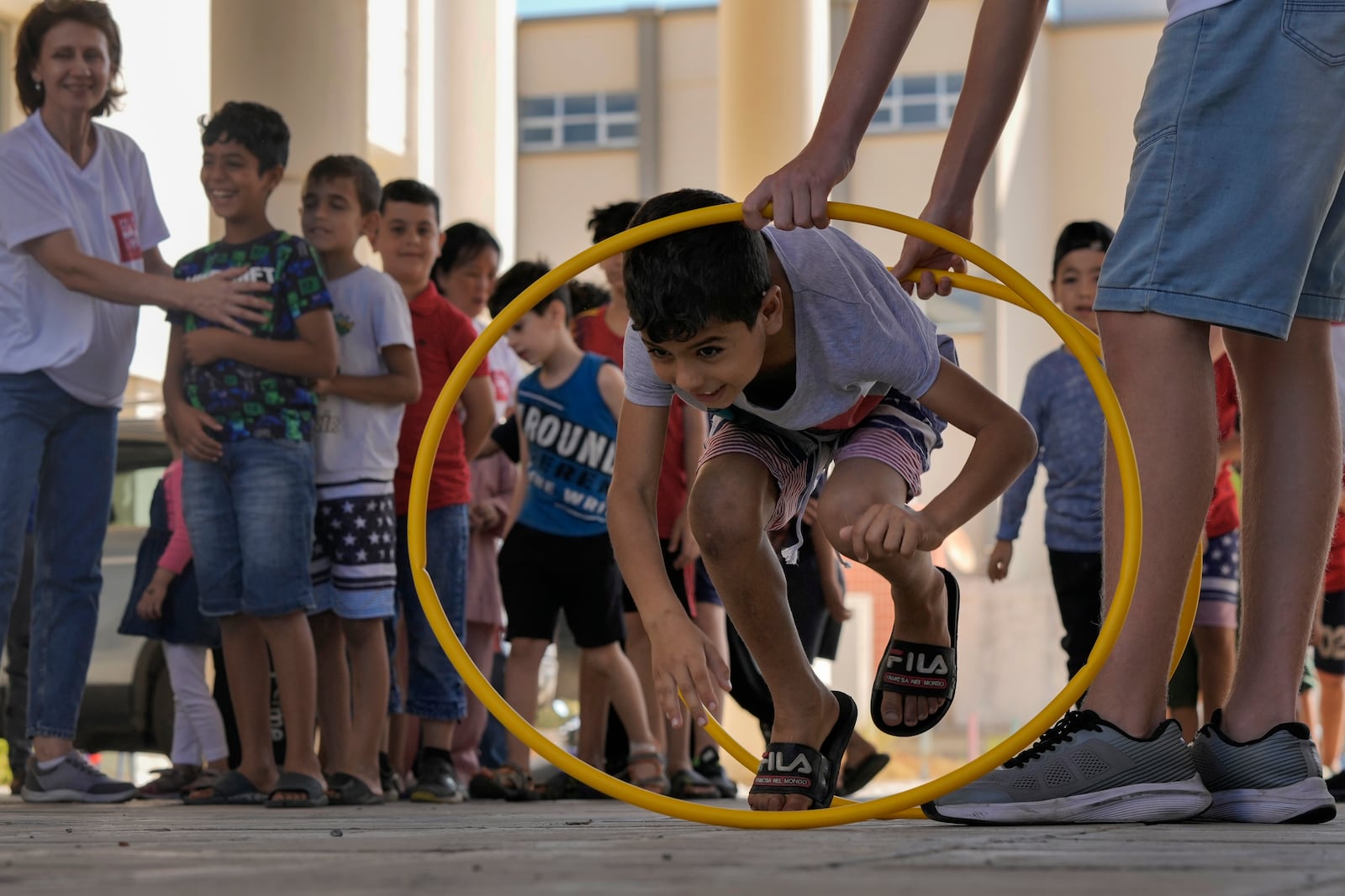 A volunteer of the Russian Cultural Center entertains displaced children at a school in Beirut, Lebanon, Thursday, Oct. 3, 2024, after fleeing the Israeli airstrikes in the south. (AP Photo/Bilal Hussein)