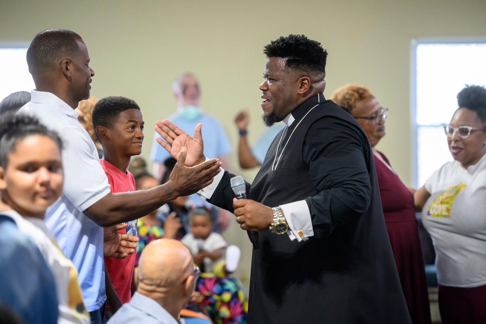 Pastor Rashad Singletary, center, greets parishioners during a service at Mt. Olive Baptist Church, Sunday, Aug. 18, 2024, in Turner Station, Md. Turner Station is located near the former site of the Francis Scott Key Bridge, which collapsed in March. (AP Photo/Steve Ruark)