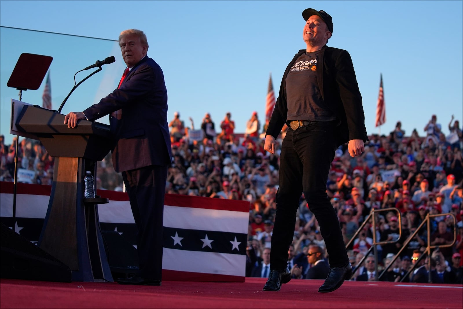 Elon Musk jumps on the stage as Republican presidential nominee former President Donald Trump speaks at a campaign rally at the Butler Farm Show, Saturday, Oct. 5, 2024, in Butler, Pa. (AP Photo/Evan Vucci)