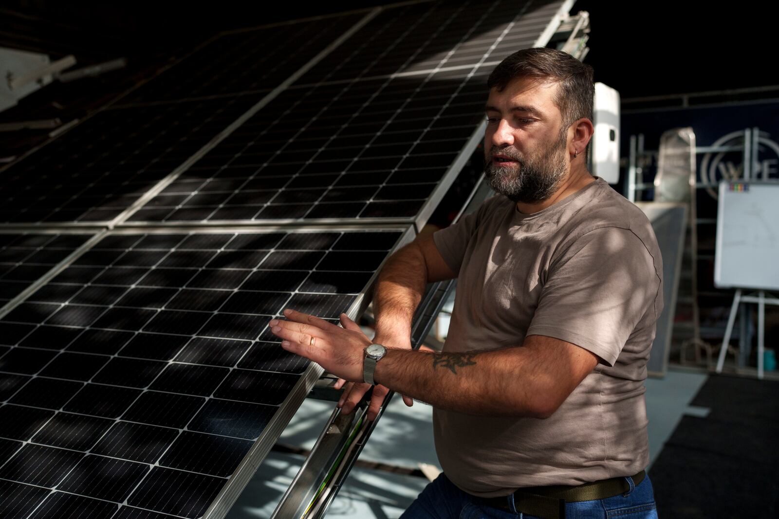 Sebastian Tirintica speaks next to solar panels in the RenewAcad training center in Petrosani, southern Romania, Friday, Oct. 11, 2024. (AP Photo/Vadim Ghirda)