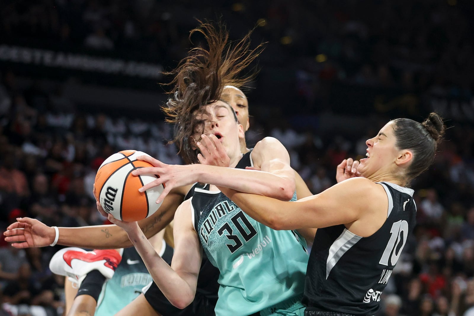 New York Liberty forward Breanna Stewart (30) grabs a rebound over Las Vegas Aces center A'ja Wilson and guard Kelsey Plum during the first half of a WNBA Semifinal game, Sunday, Oct. 6, 2024, in Las Vegas. (AP Photo/Ian Maule)