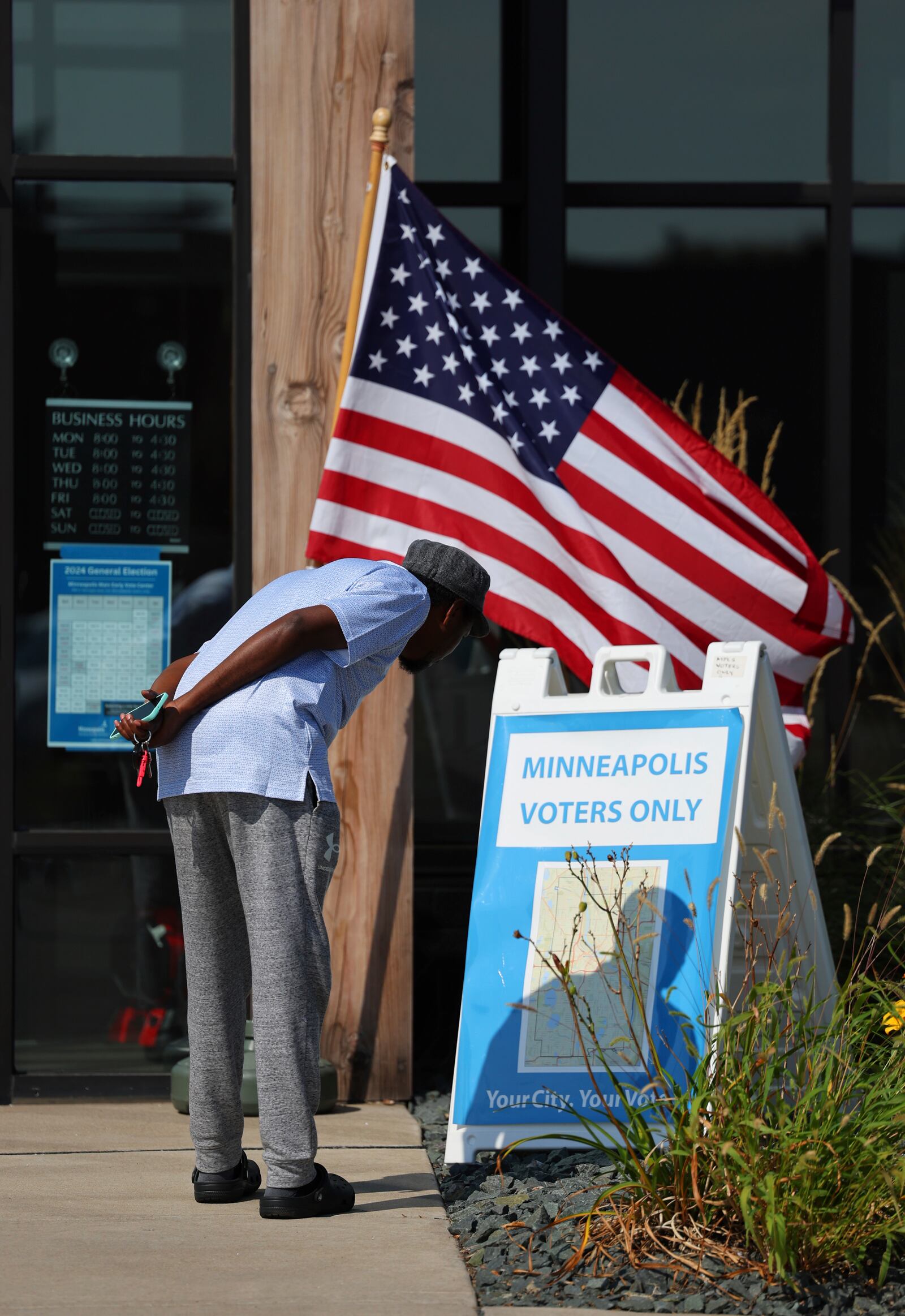 A member of the public looks at a Minneapolis map outside of the City of Minneapolis early voting center, Thursday, Sept. 19, 2024, in St. Paul, Minn. In-person voting in the 2024 presidential contest begins Friday in three states, including Democratic vice presidential candidate Tim Walz's home state of Minnesota, with just over six weeks left before Election Day. (AP Photo/Adam Bettcher)