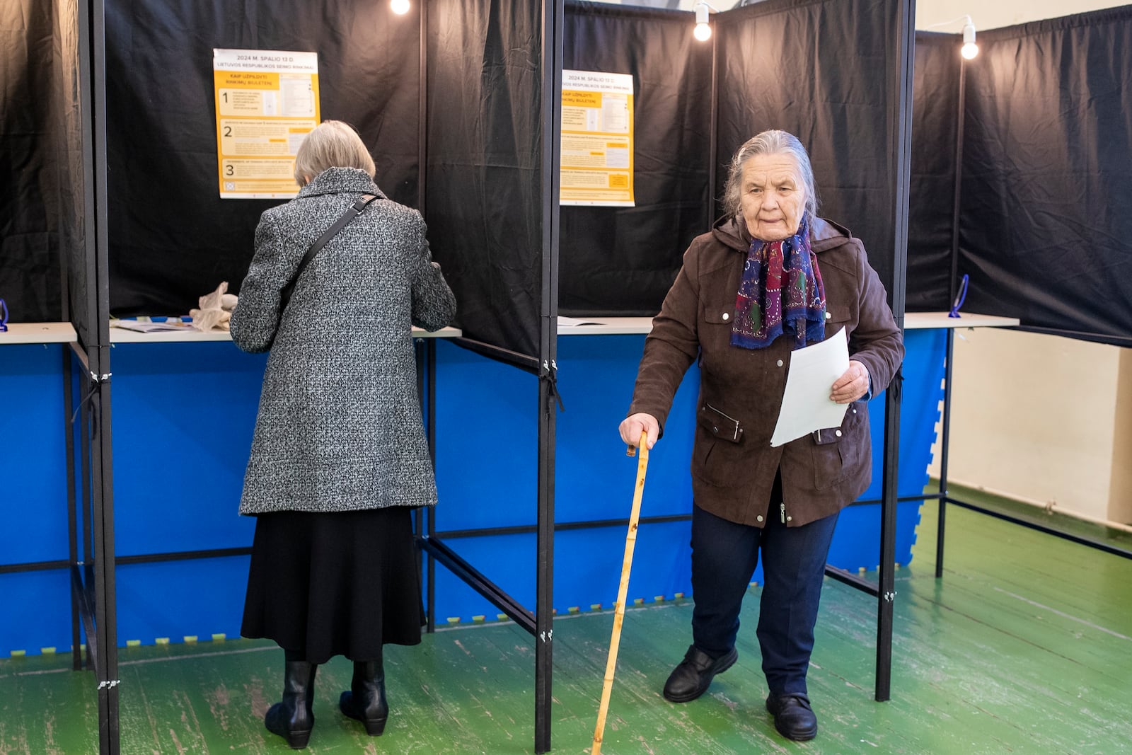 A woman leaves a polling booth at a polling station during the first round of voting in a parliamentary election, in Vilnius, Lithuania, Sunday, Oct. 13, 2024. (AP Photo/Mindaugas Kulbis)