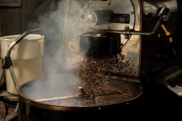 Coffee beans fall into the cooling tray of a roasting machine at Fuego Coffee Roasters' roasting facility, Friday, March 21, 2025, in Rochester, N.Y. (Max Conway via AP)