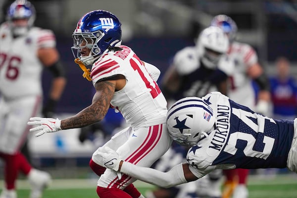 Dallas Cowboys safety Israel Mukuamu (24) tackles New York Giants wide receiver Wan'Dale Robinson (17) after a catch during the second half of an NFL football game in Arlington, Texas, Thursday, Nov. 28, 2024. (AP Photo/Tony Gutierrez)