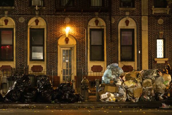 Piles of trash line a sidewalk, Saturday, Nov. 16, 2024, in the Brooklyn borough of New York. (AP Photo/Yuki Iwamura)