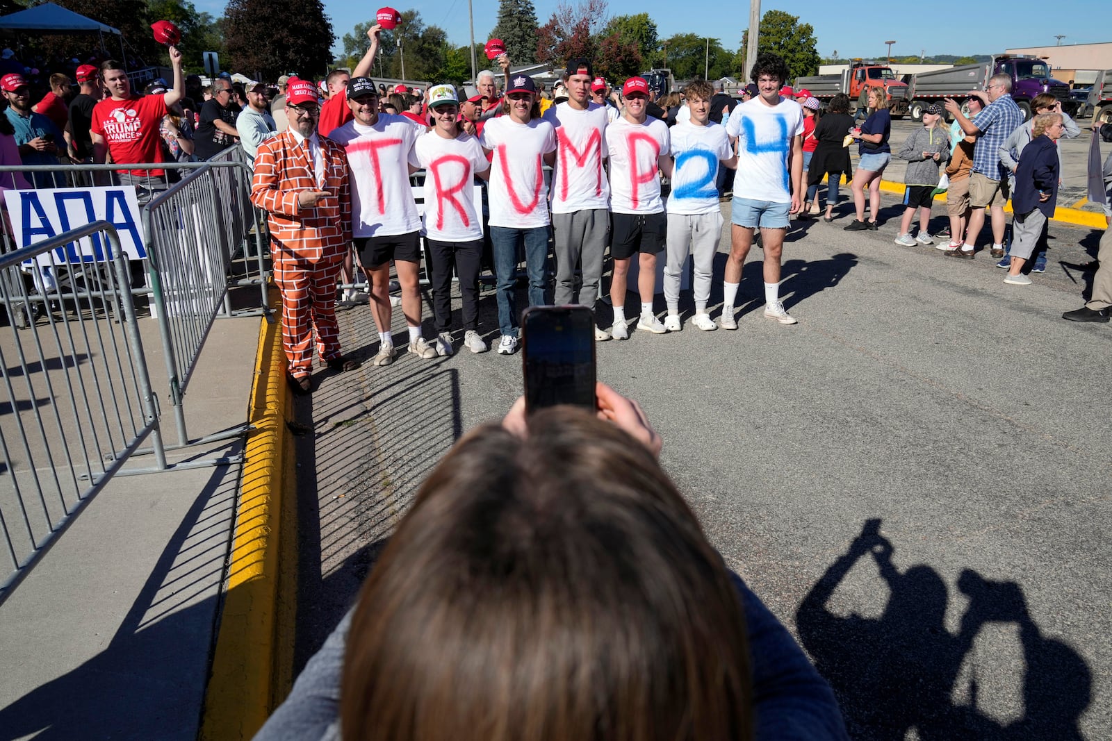 Supporters pose for a photo while waiting for Republican presidential nominee former President Donald Trump to arrive at a rally, Saturday, Sept. 28, 2024, in Prairie du Chien, Wis. (AP Photo/Charlie Neibergall)