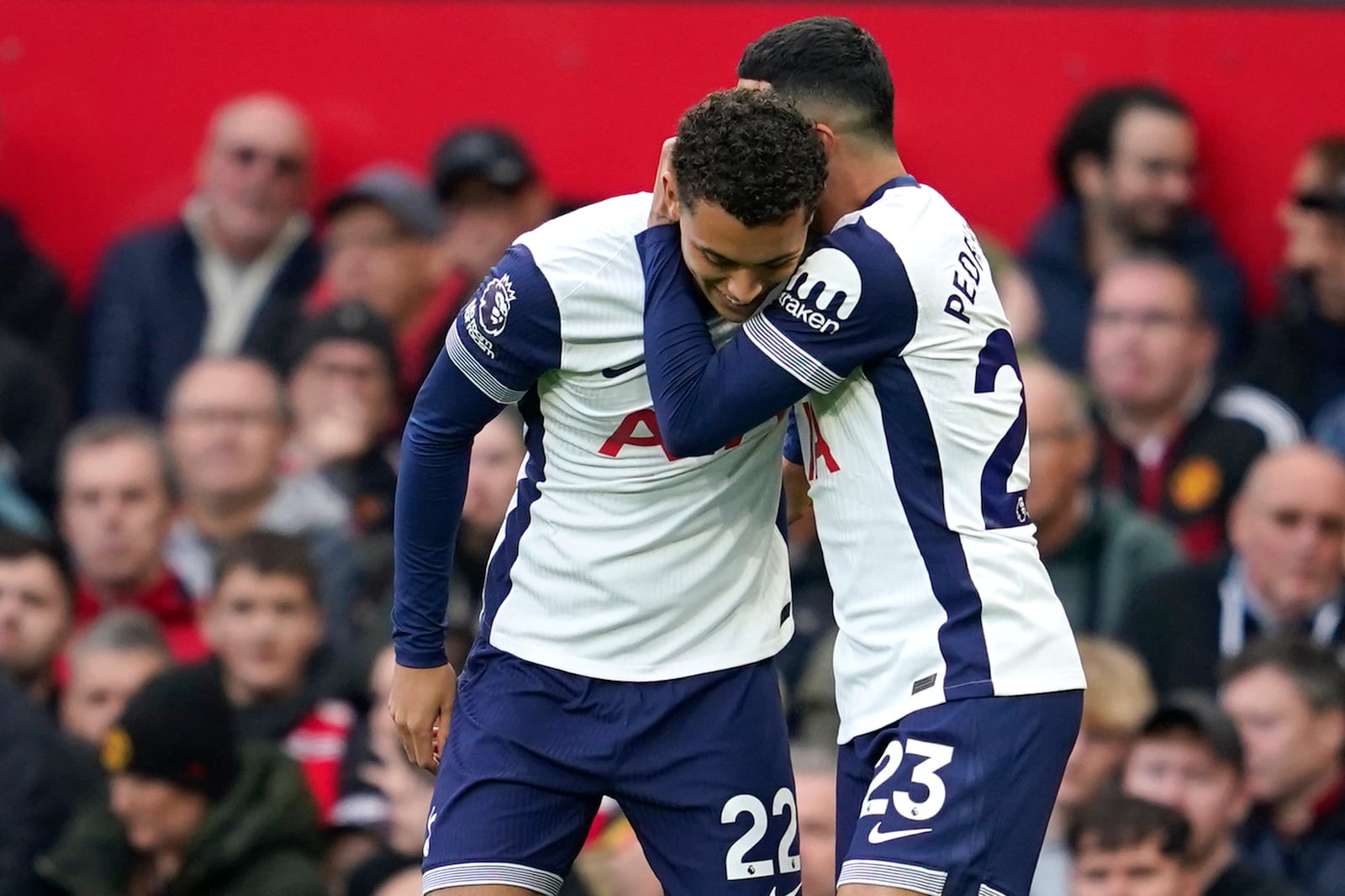 Tottenham's Brennan Johnson, left, celebrates after scoring his side's opening goal during the English Premier League soccer match between Manchester United and Tottenham Hotspur at Old Trafford stadium in Manchester, England, Sunday, Sept. 29, 2024. (AP Photo/Dave Thompson)