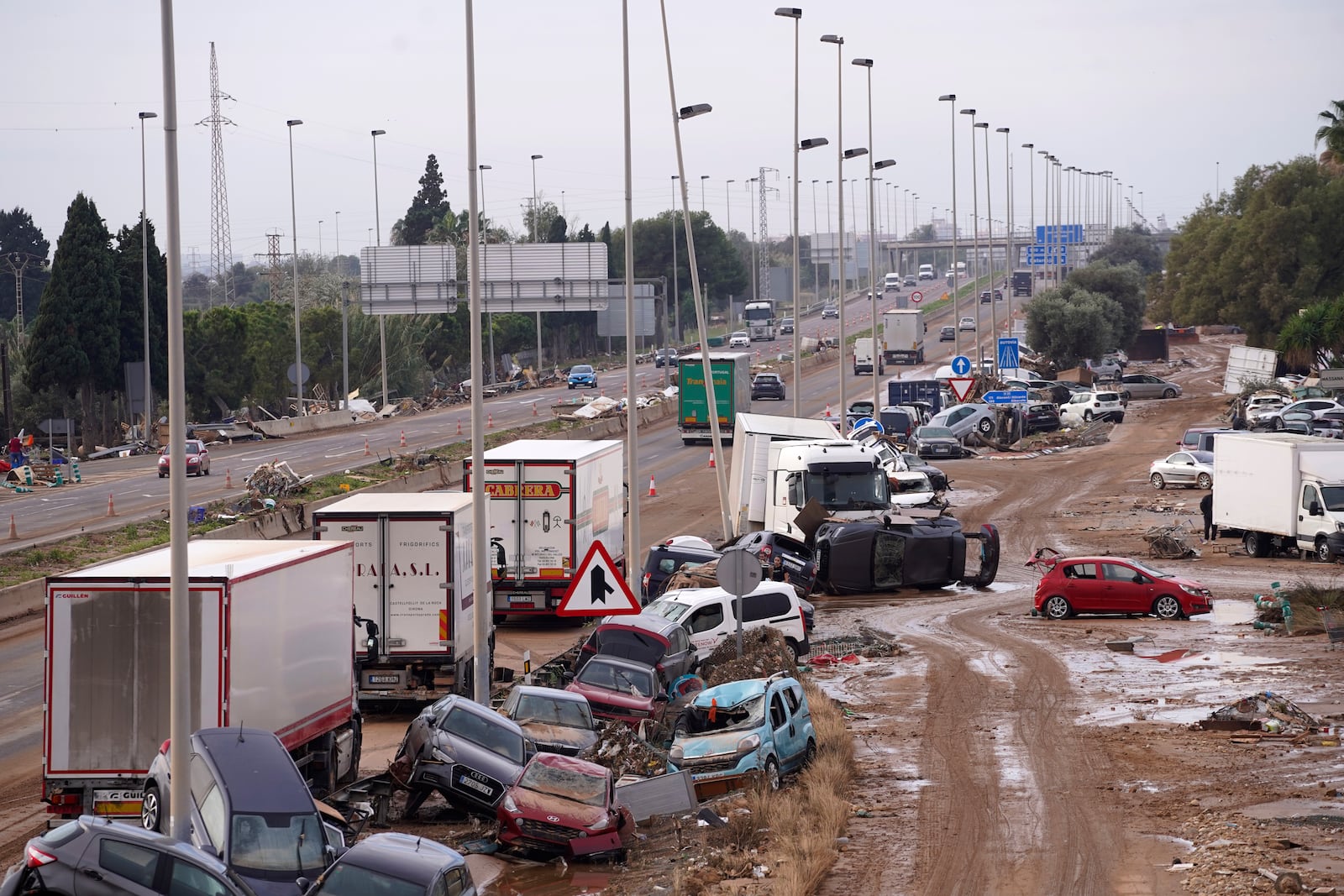 Cars are strewn on the side on a main road after floods in Valencia, Spain, Friday, Nov. 1, 2024. (AP Photo/Alberto Saiz)