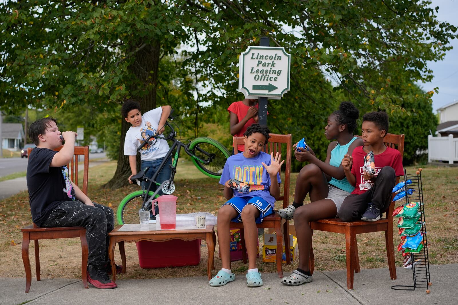 Neighborhood kids gather to sell Kool-Aid and chips, Tuesday, Sept. 17, 2024, in Springfield, Ohio. Some were kept home from school because of the bomb threats at their schools, and if that happens again, they plan to be at the corner with Kool-Aid and chips again tomorrow. (AP Photo/Carolyn Kaster)