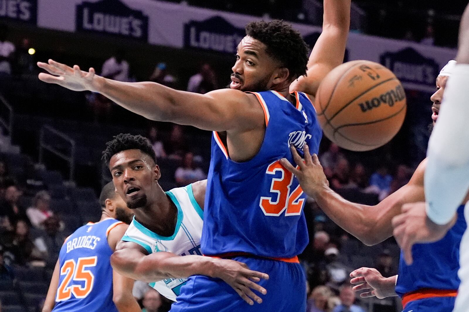 Charlotte Hornets forward Brandon Miller passes around New York Knicks center Karl-Anthony Towns during the first half of a preseason NBA basketball game against the Charlotte Hornets, Sunday, Oct. 6, 2024, in Charlotte, N.C. (AP Photo/Chris Carlson)