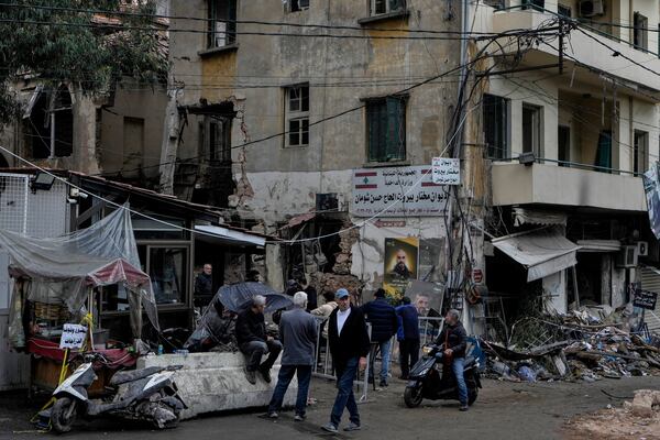 People stand next to a destroyed building hit on Monday evening by an Israeli airstrike in central Beirut, Lebanon, Tuesday, Nov. 19, 2024. (AP Photo/Bilal Hussein)