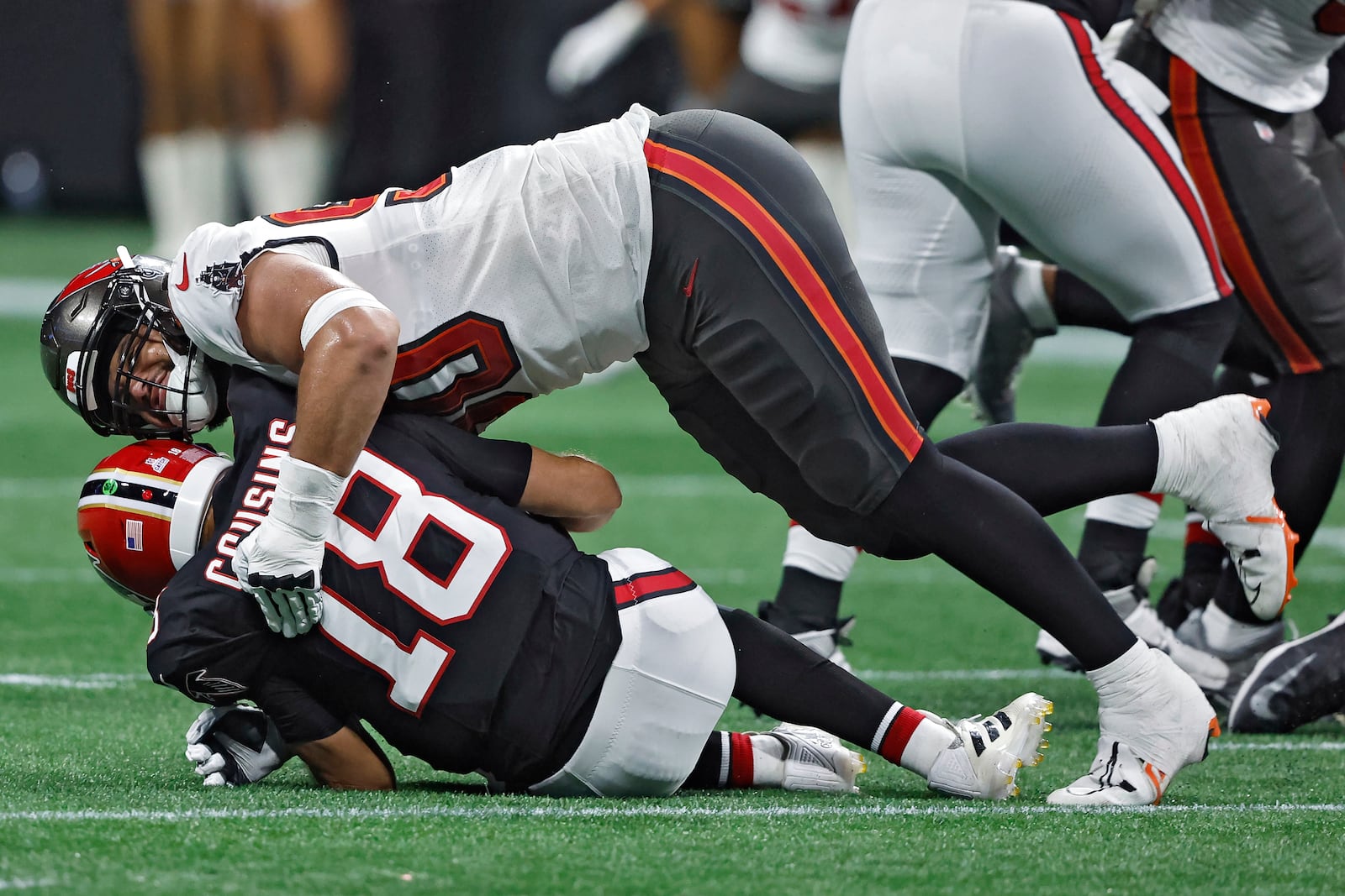 Tampa Bay Buccaneers defensive end Logan Hall (90) sacks Atlanta Falcons quarterback Kirk Cousins (18) during the first half of an NFL football game Thursday, Oct. 3, 2024, in Atlanta. (AP Photo/Butch Dill)