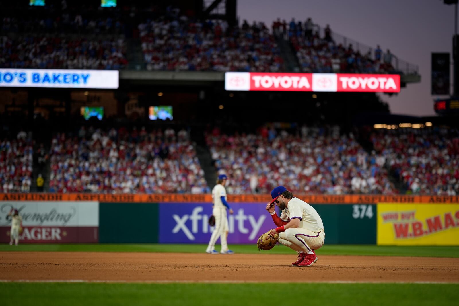 Philadelphia Phillies first base Bryce Harper rests during a pitching change during the eighth inning of Game 1 of a baseball NL Division Series against the New York Mets, Saturday, Oct. 5, 2024, in Philadelphia. (AP Photo/Matt Slocum)