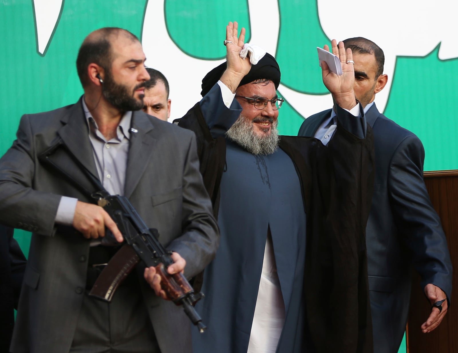 FILE - Hezbollah leader Hassan Nasrallah, center, escorted by his bodyguards, waves to a crowd of tens of thousands of supporters during a rally in Beirut's southern suburbs, Monday Sept. 17, 2012. (AP Photo/Hussein Malla, File)