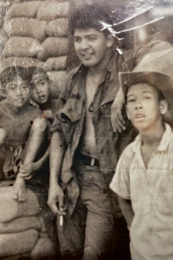 This photo provided by George Bennett shows Bennett with children from the Dau Tieng village during his service in Vietnam from 1966 to 1967. (George Bennett via AP)