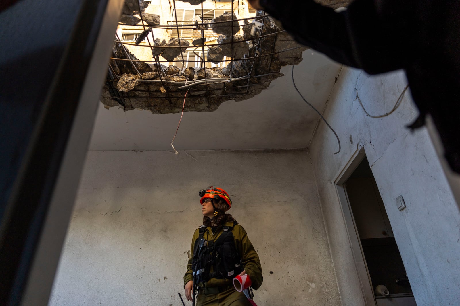 An officer from the home front command military unit examines the damaged apartment after it was hit by a rocket fired from Lebanon in Kiryat Yam, northern Israel, Tuesday, Oct. 8, 2024. (AP Photo/Ariel Schalit)