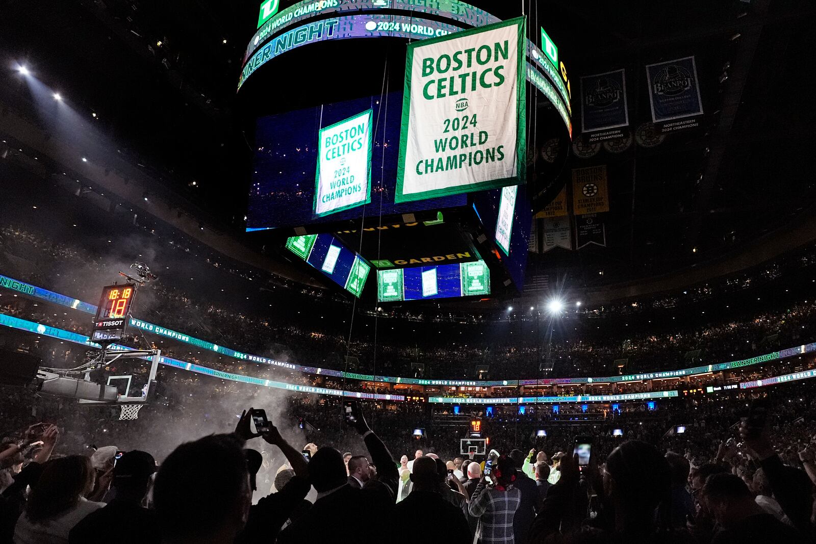 The Boston Celtics 2024 World Championship banner is raised prior to an NBA basketball game against the New York Knicks, Tuesday, Oct. 22, 2024, in Boston. (AP Photo/Charles Krupa)