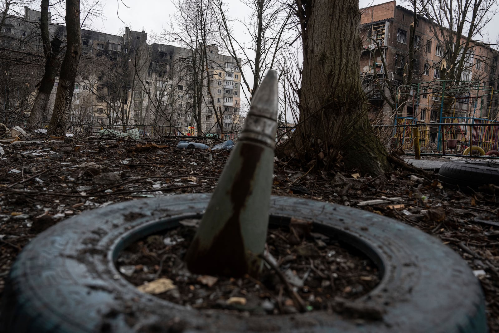 FILE - A part of a rocket sticks from a ground in front of a residential building which was heavily bombed by Russian forces in the frontline city of Vuhledar, Ukraine, Feb. 25, 2023. (AP Photo/Evgeniy Maloletka)