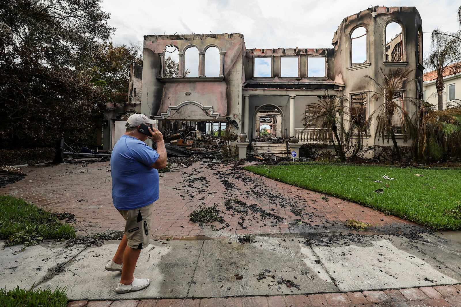 Joe Daum looks at the remains of a friend's home that burned during Hurricane Helene on Davis Island Saturday, Sept. 28, 2024, in Tampa, Fla. (AP Photo/Mike Carlson)