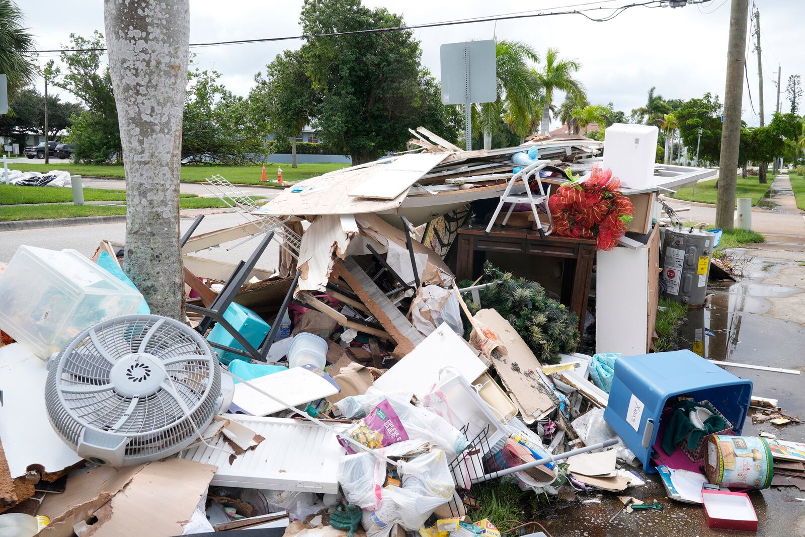 Piles of debris line the sidewalks of Punta Gorda's historic neighborhood damaged by Hurricane Helene, Tuesday, Oct. 8, 2024, in Punta Gorda, Fla., as the area braces for possible storm surge from Hurricane Milton. (AP Photo/Marta Lavandier)