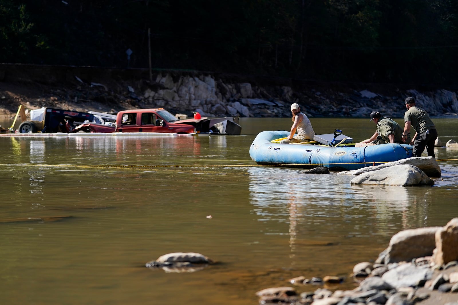 Civilian volunteers using an inflatable raft deliver supplies to residents in the aftermath of Hurricane Helene on Tuesday, Oct. 8, 2024, in Burnsville, N.C. (AP Photo/Erik Verduzco)