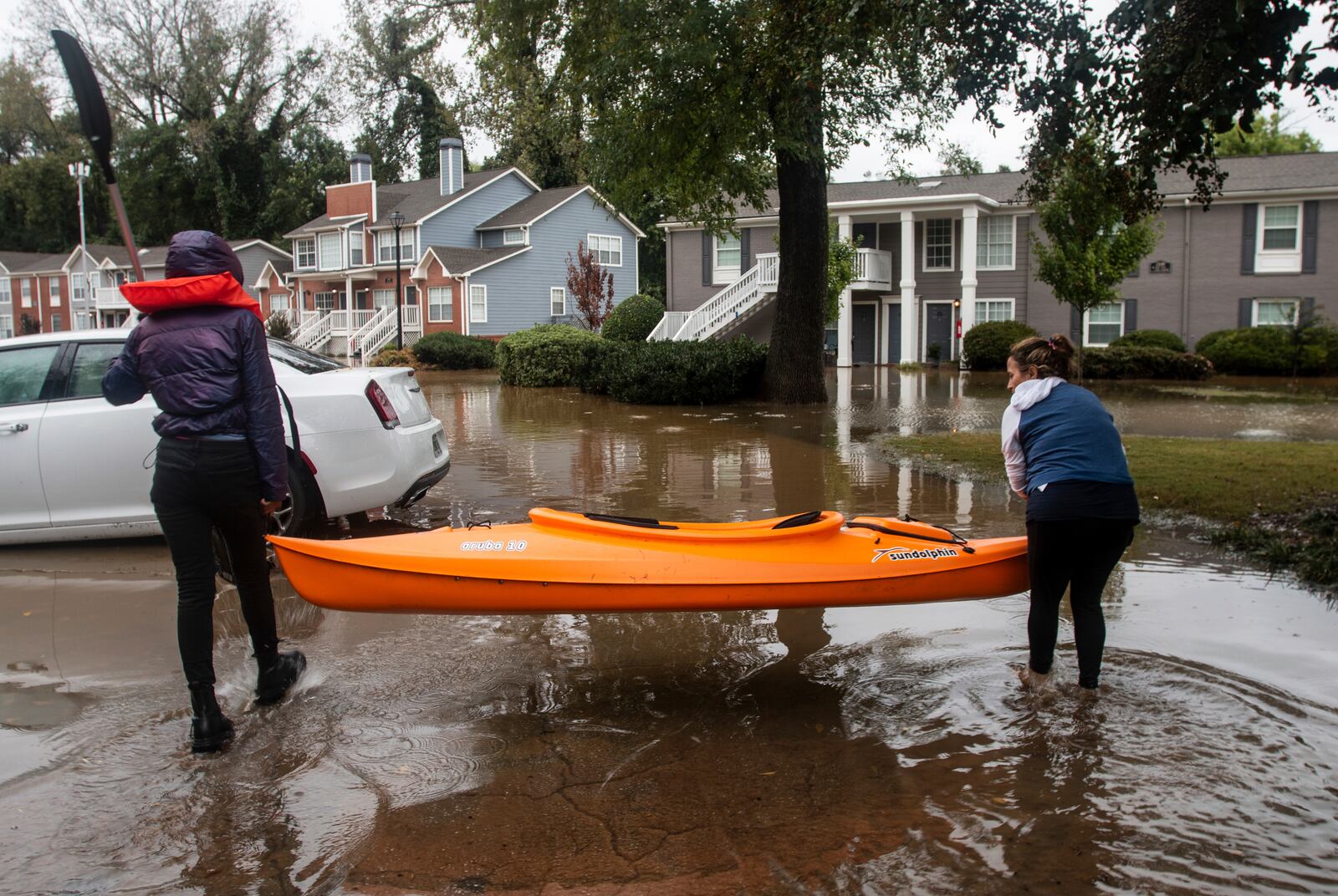 Two women maneuver a kayak into position to retrieve belongings at a flooded apartment complex after Hurricane Helene passed the area on Friday, Sept. 27, 2024, in Atlanta. (AP Photo/Ron Harris)