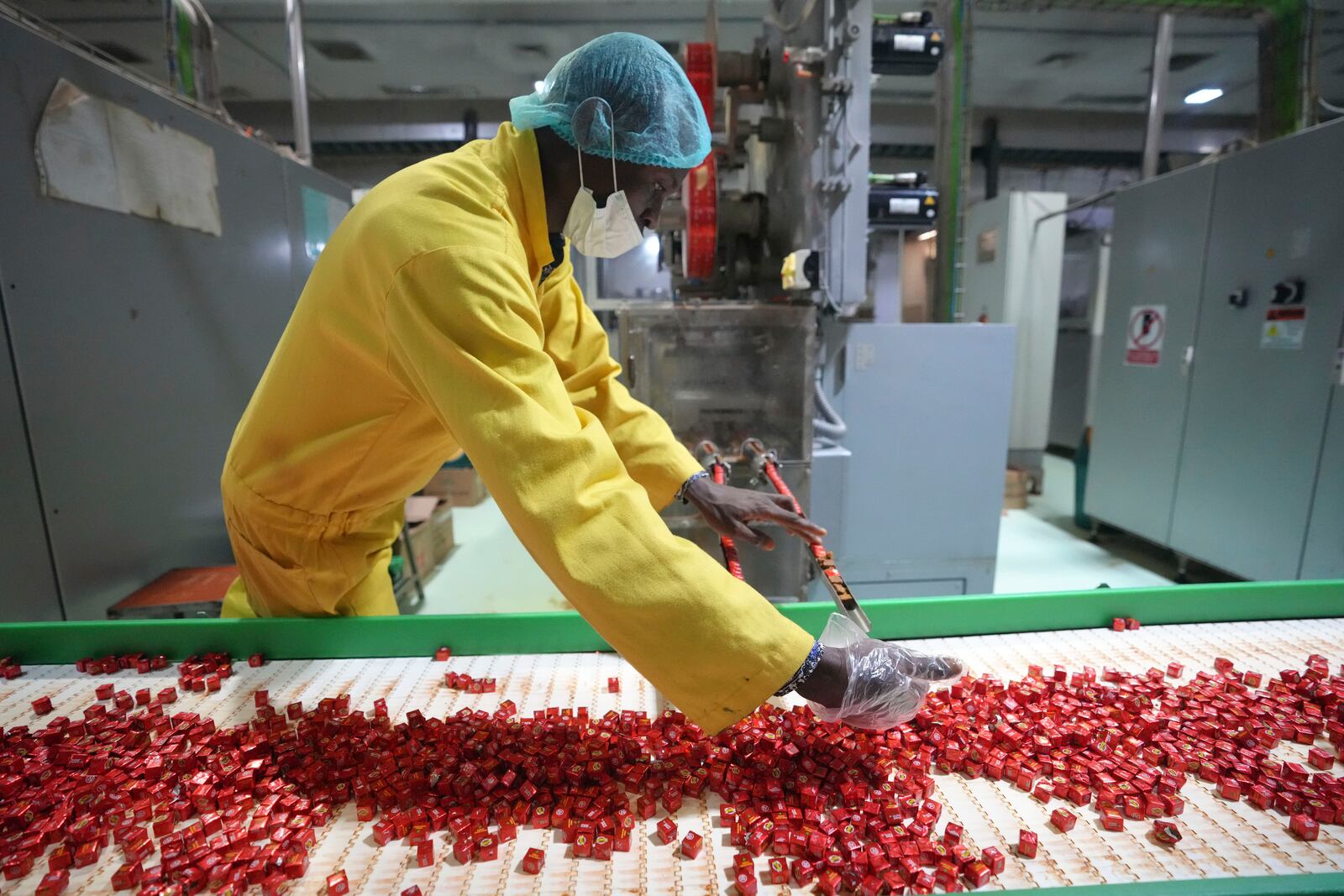 A worker checks bouillon cubes ahead of packaging at the Sweet Nutrition factory in Ota, Nigeria, Thursday, Sept. 12, 2024. (AP Photo/Sunday Alamba)