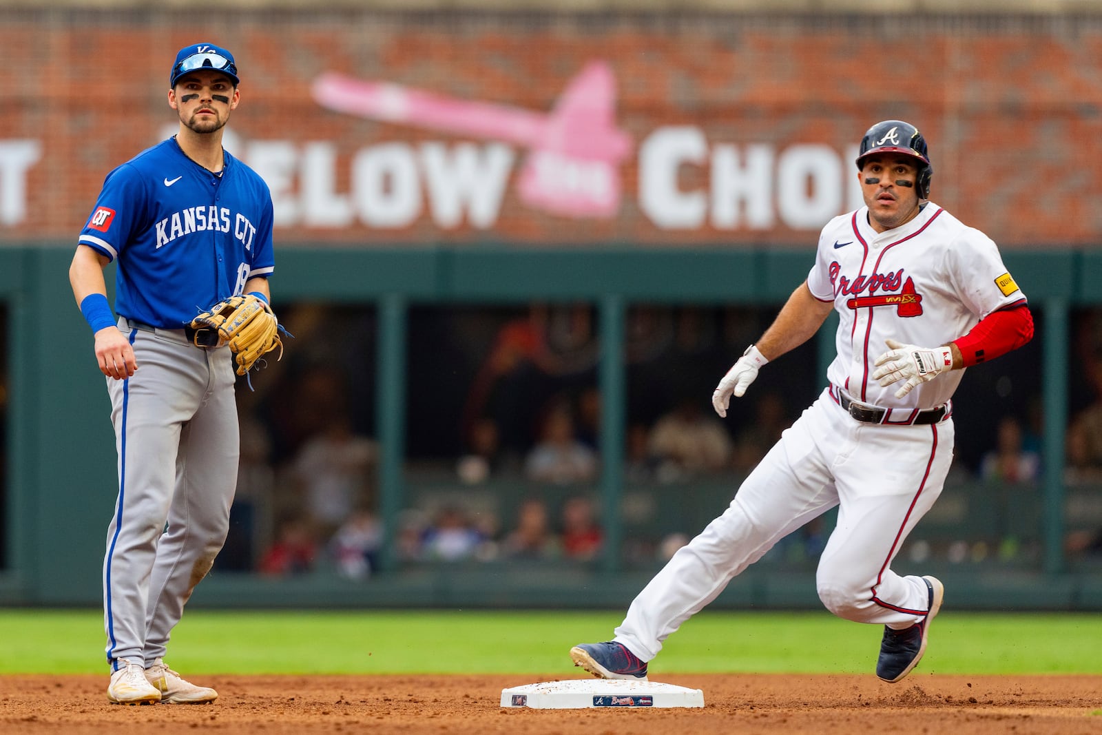 Atlanta Braves' Travis d'Arnaud, right, tags second base after a hit by Atlanta Braves catcher Sean Murphy while Kansas City Royals second baseman Michael Massey, left, waits for the throw to him in the fourth inning of a baseball game, Sunday, Sept. 29, 2024, in Atlanta. (AP Photo/Jason Allen)